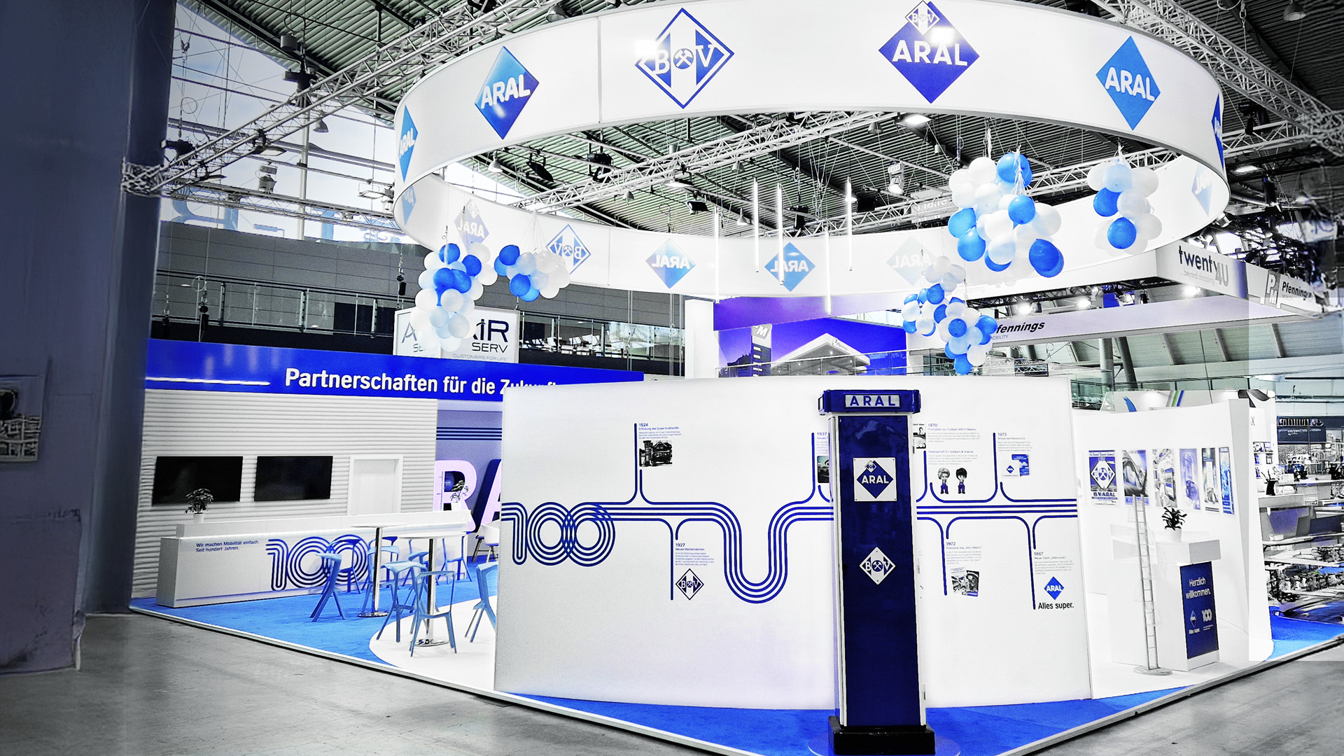 Messestand von Aral Marketing mit dem Motto "100 Jahre Aral" bei der UNITI Messe. Das Bild zeigt eine alte Zapfsäule sowie die Geschichte der letzten 100 Jahre.