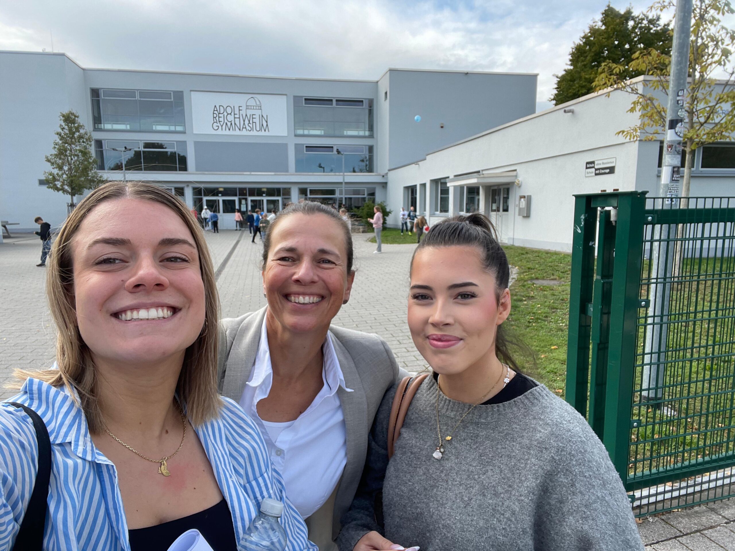 2 Azubis von wegner und partner mit Silvana vor dem Adolf Reichwein Gymnasium.