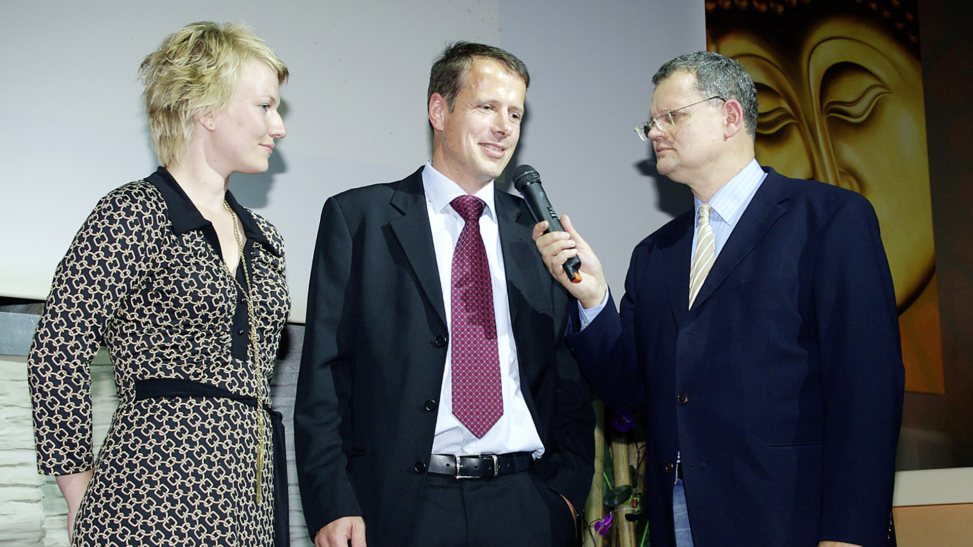 Interview Situation und der Mann in der Mitte wird von dem Mann rechts interviewt mit einem Mikrofon